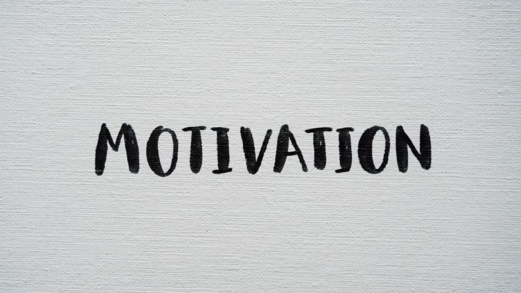 Inspirational word 'Motivation' in black on a white textured canvas background.